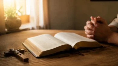 Bíblia aberta no Livro dos Salmos com crucifixo e mãos em oração
