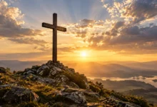 Cruz de Cristo sobre uma colina iluminada pelo sol nascente